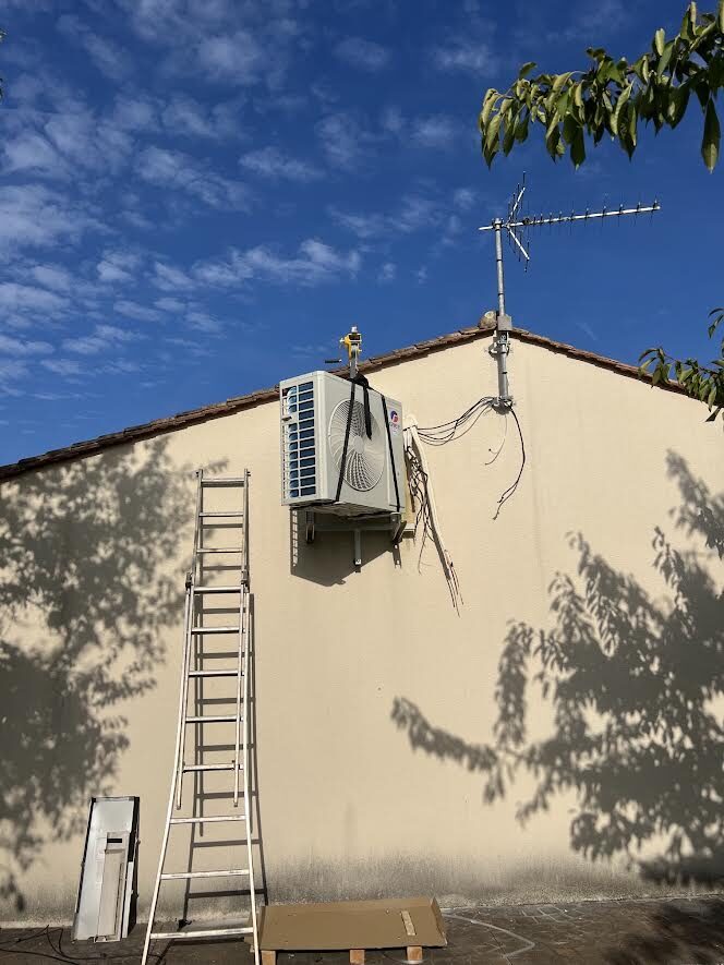 Unité extérieure installée en hauteur sur une maison
