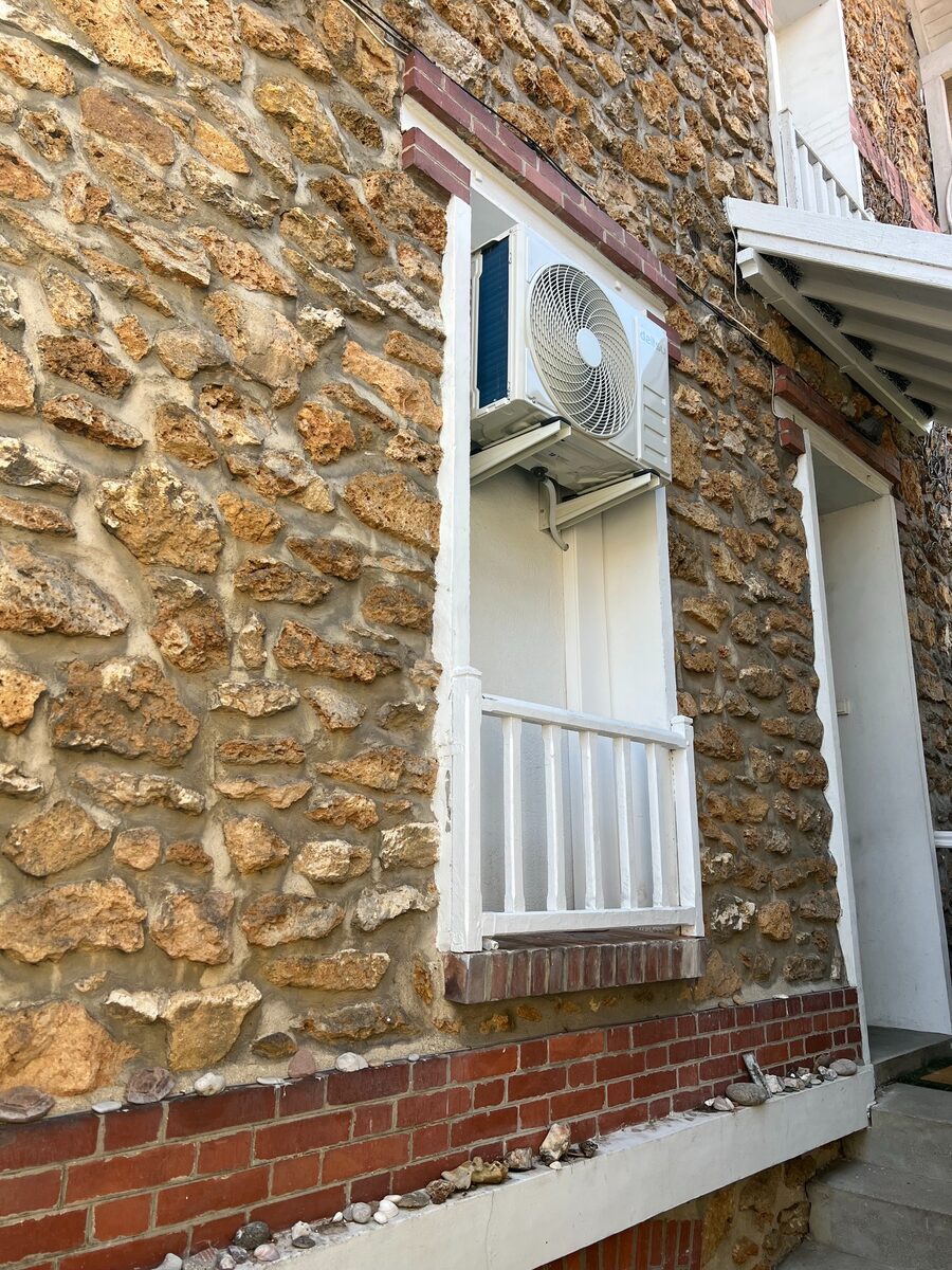 Unité extérieure Daitsu intégrée dans une façade en pierre